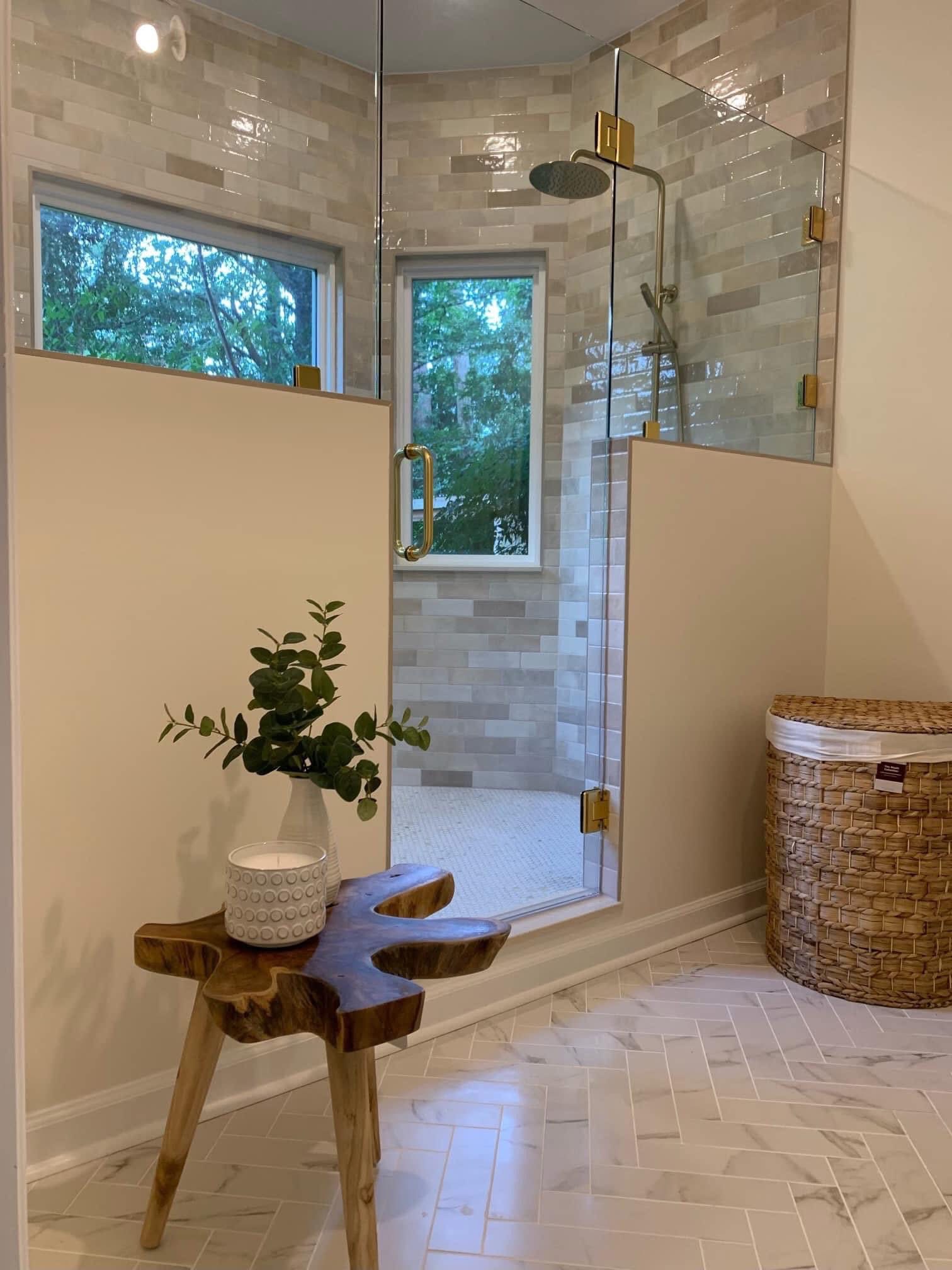 Bathroom with glass shower enclosure and warm stone tile