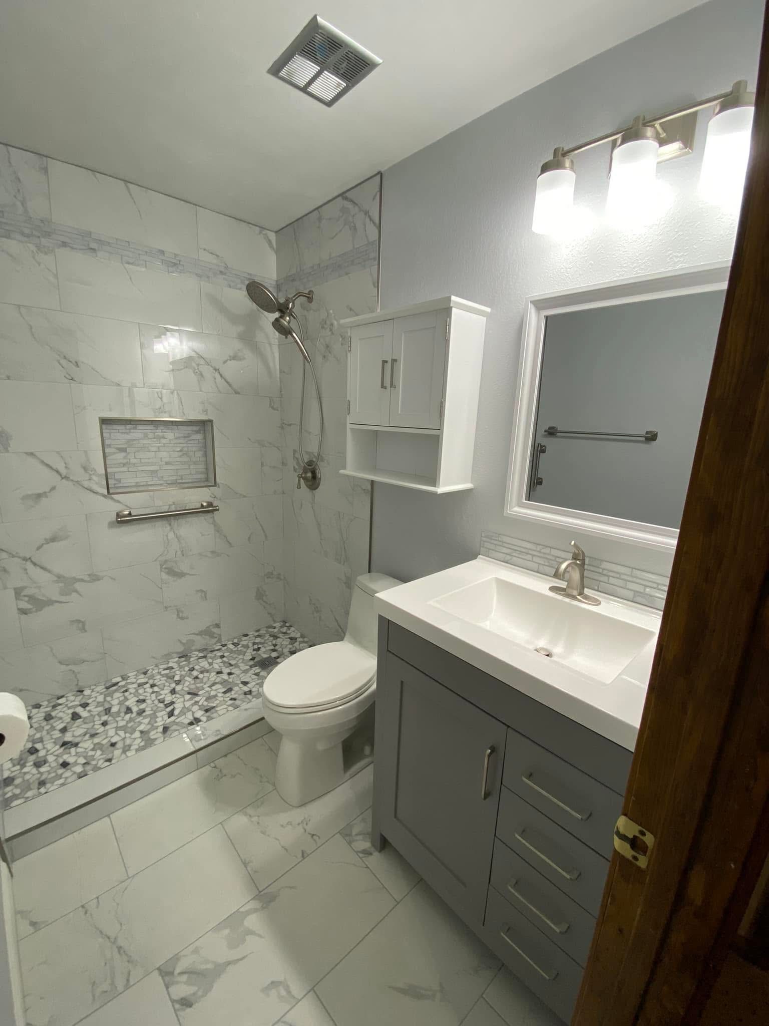 Bathroom with marble-look tile, vanity and shower