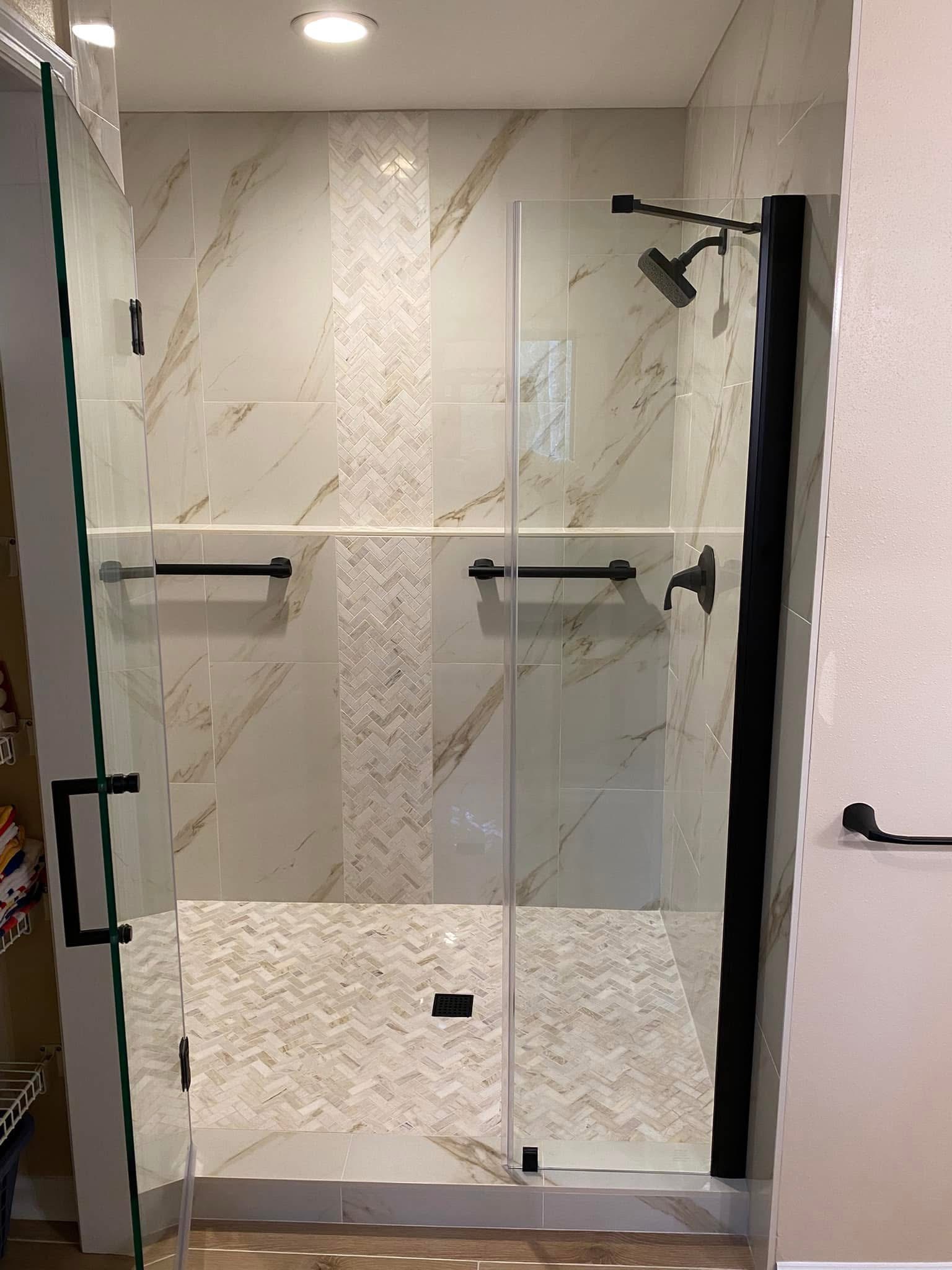 Glass shower enclosure with marble-look tile