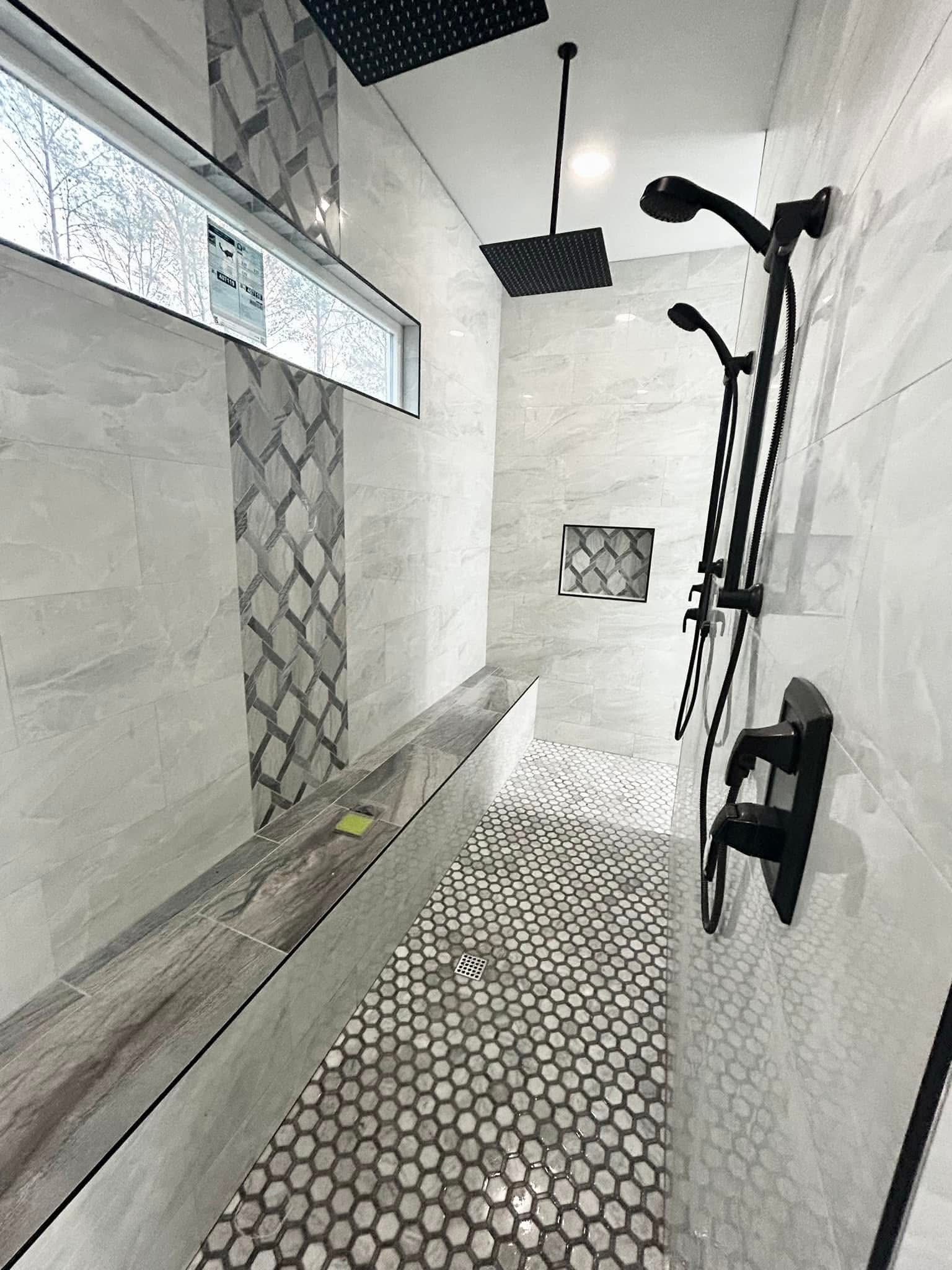 Shower with black fixtures and patterned floor