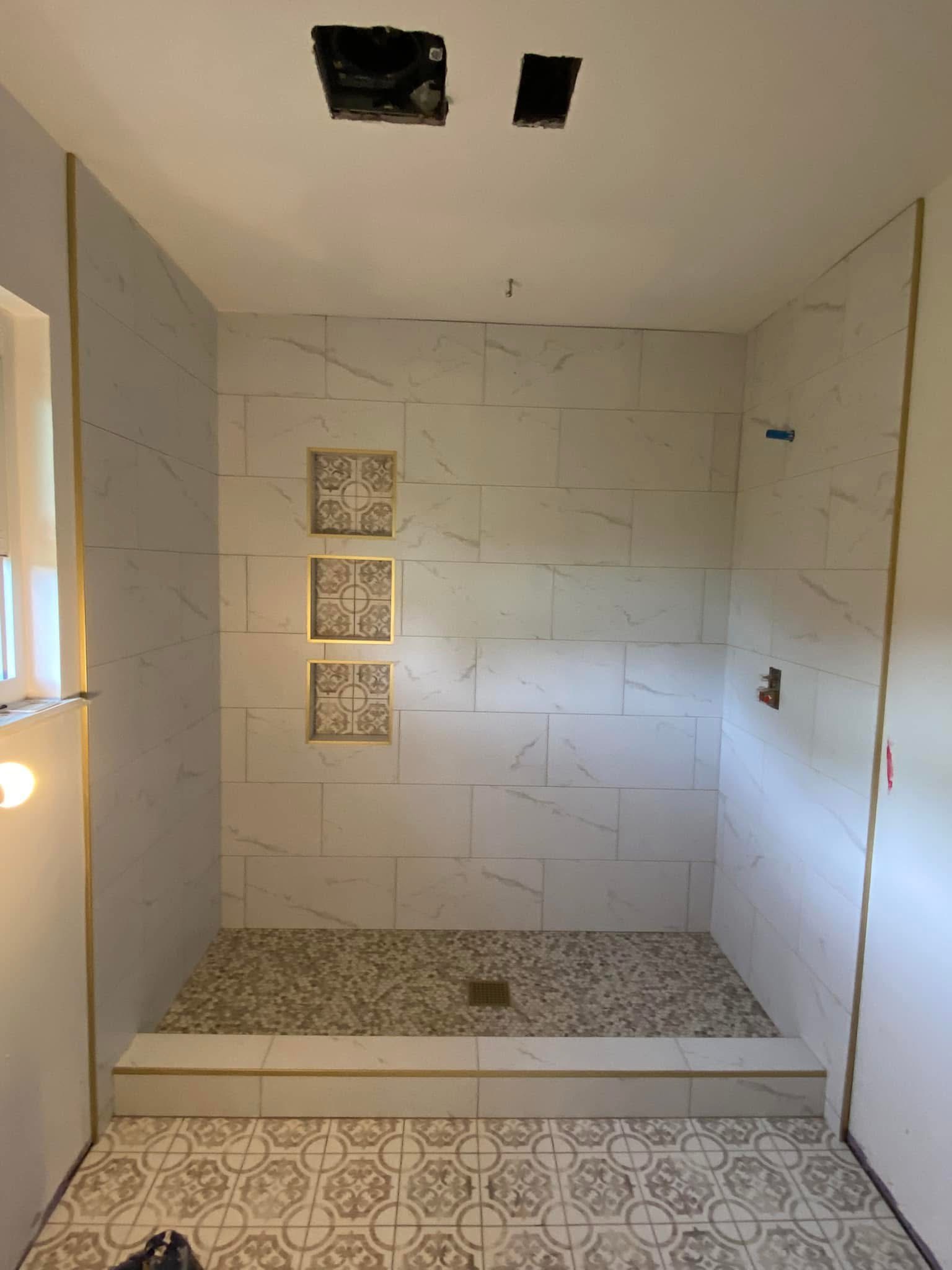 Tiled shower with niches and pebble floor