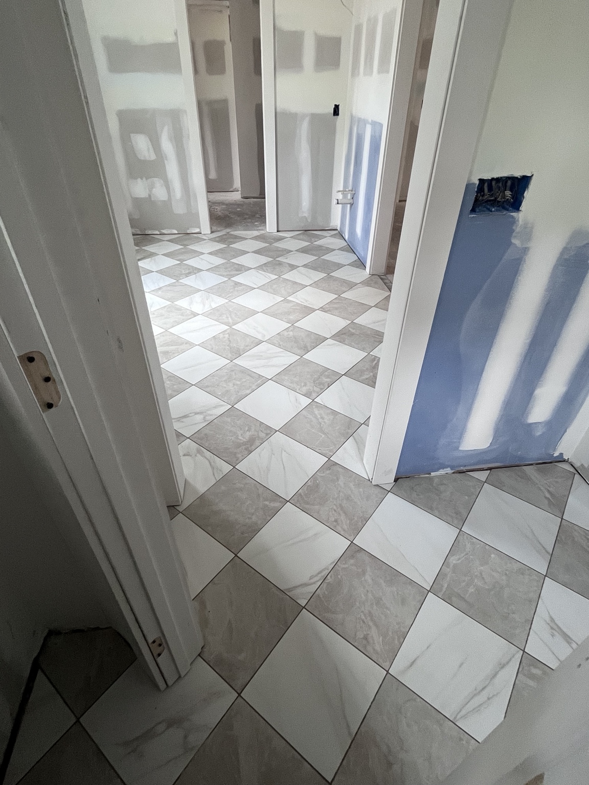 Diamond-pattern tile flooring through a hallway