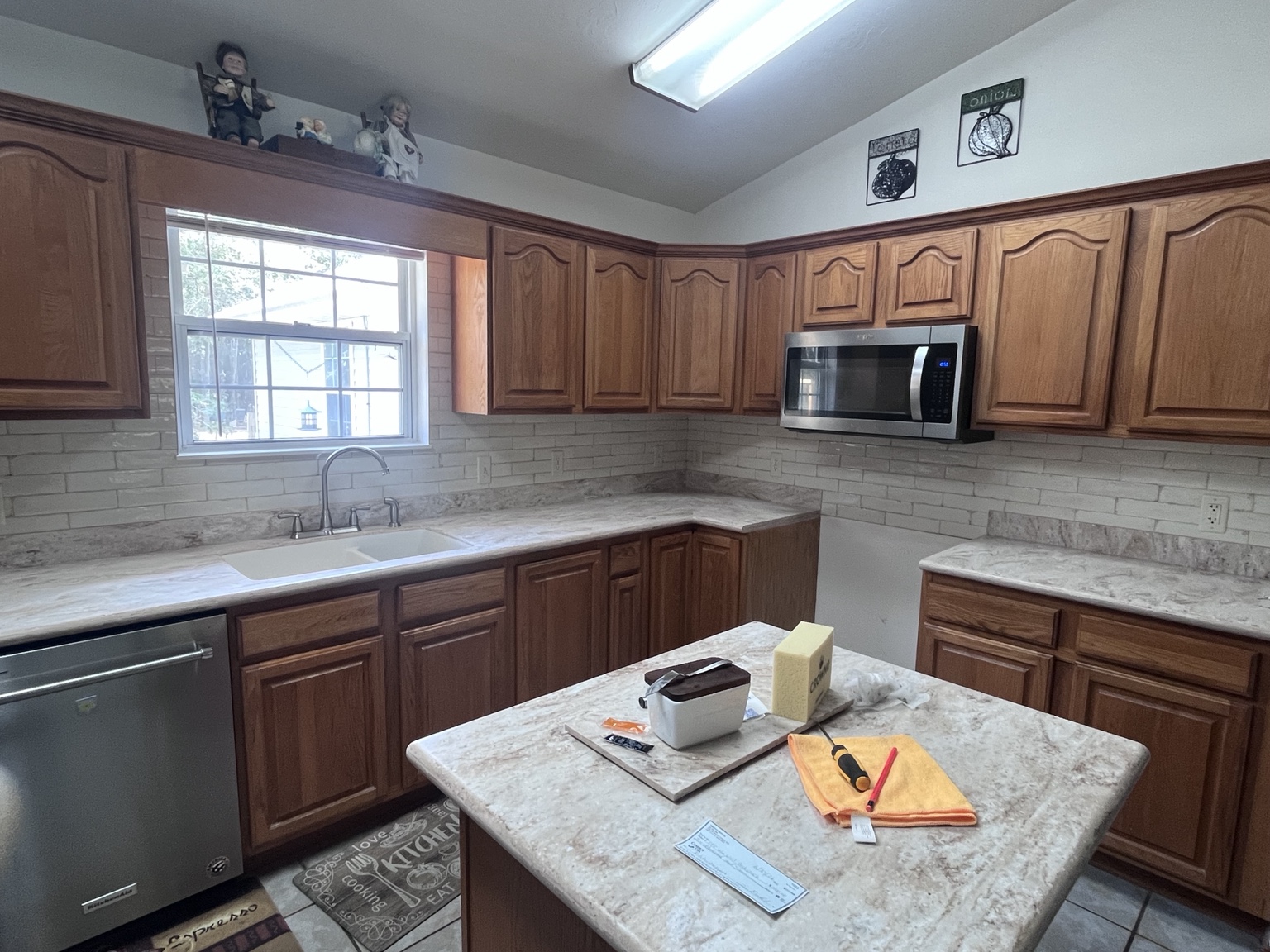 Kitchen with pale tile backsplash and wood cabinets