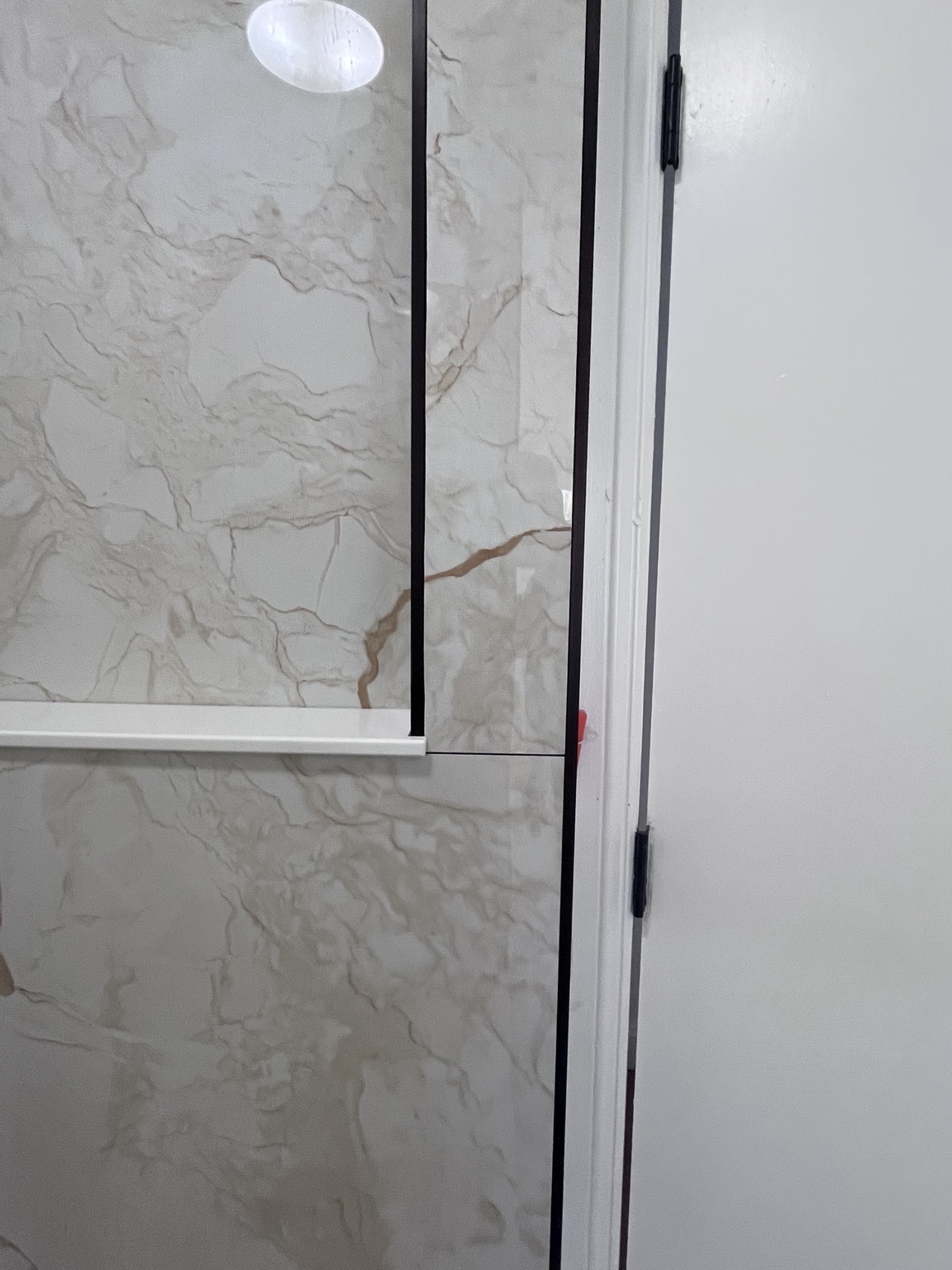 Marble-look tile and shower glass detail