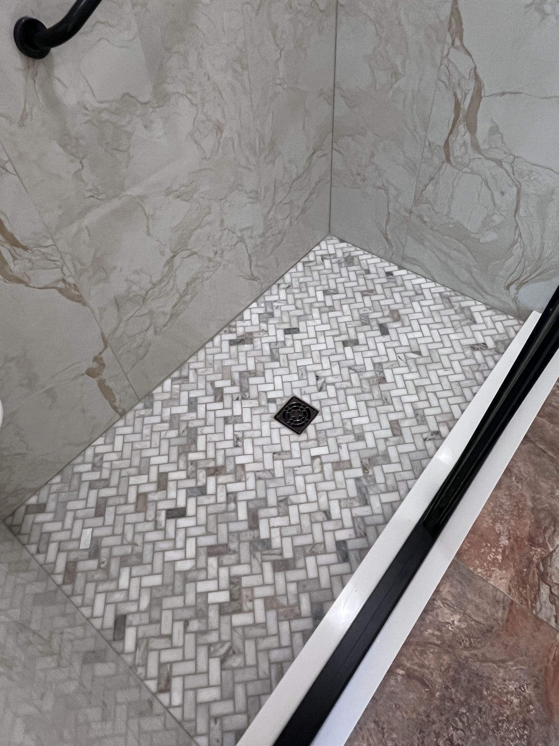 Mosaic shower floor and tiled walls