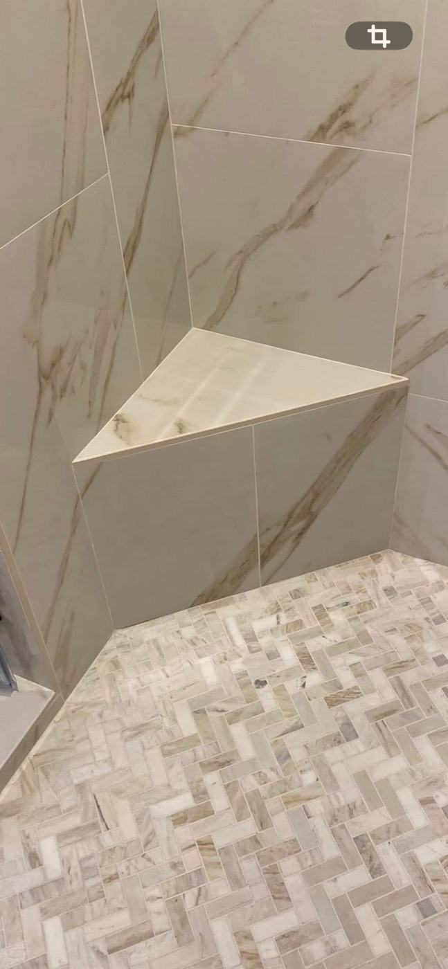 Corner shower shelf above a mosaic floor