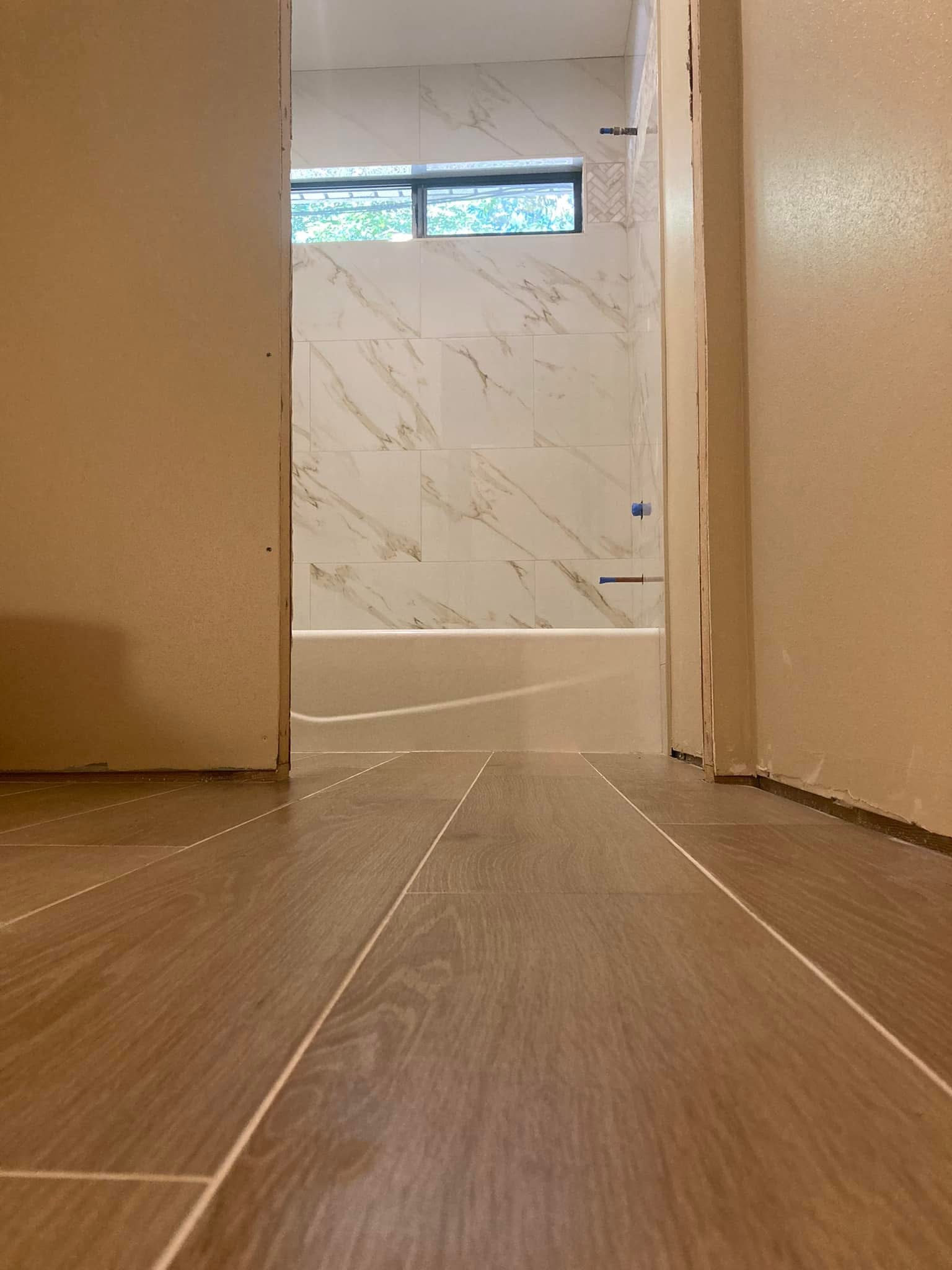 Wood-look plank tile floor toward a bathroom