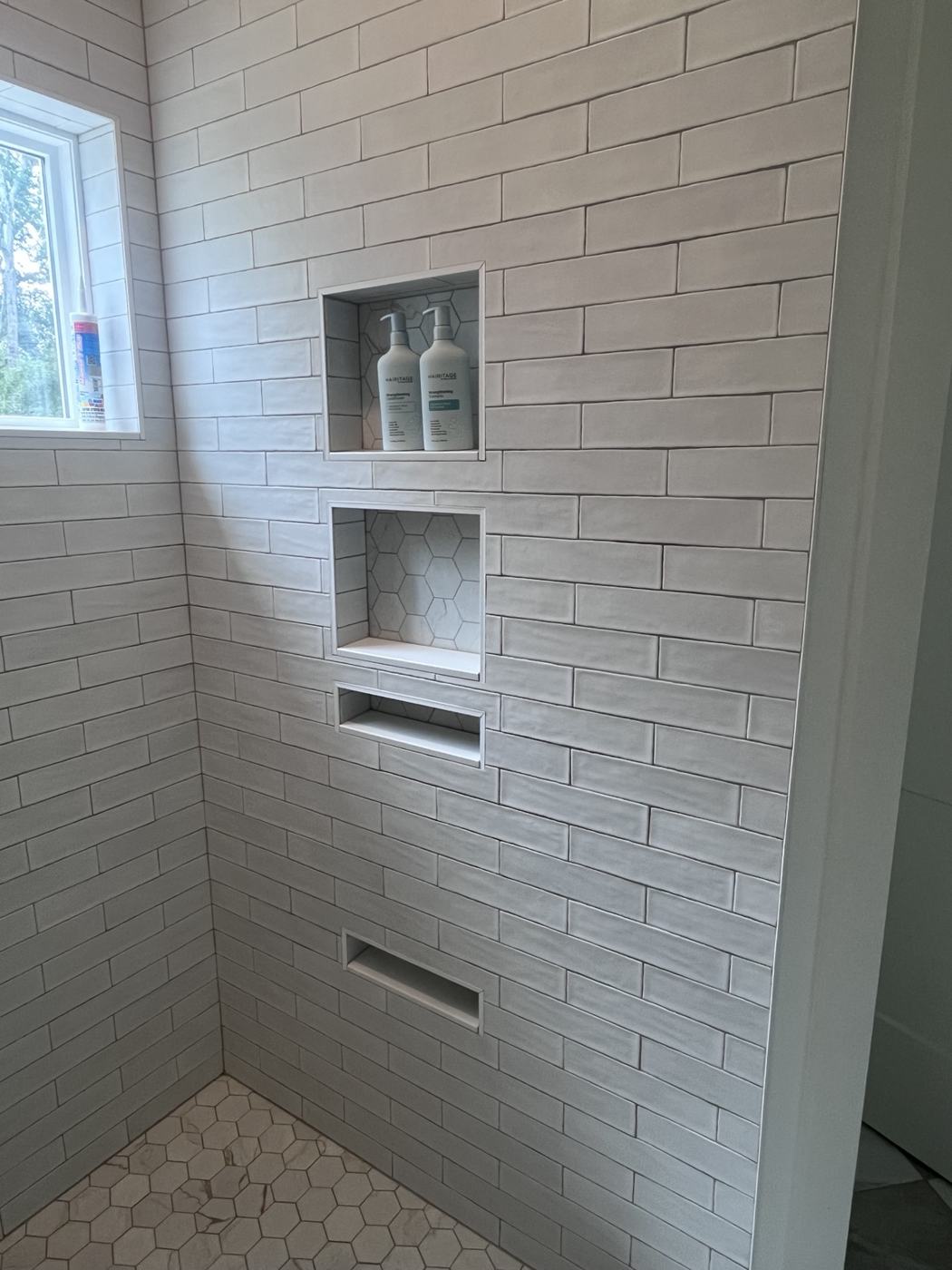 Stacked shower niches in white tile