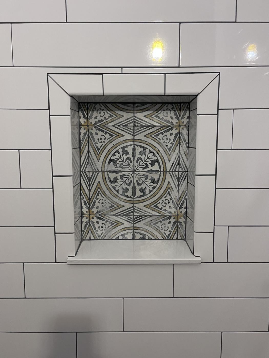 Decorative patterned tile inside a shower niche
