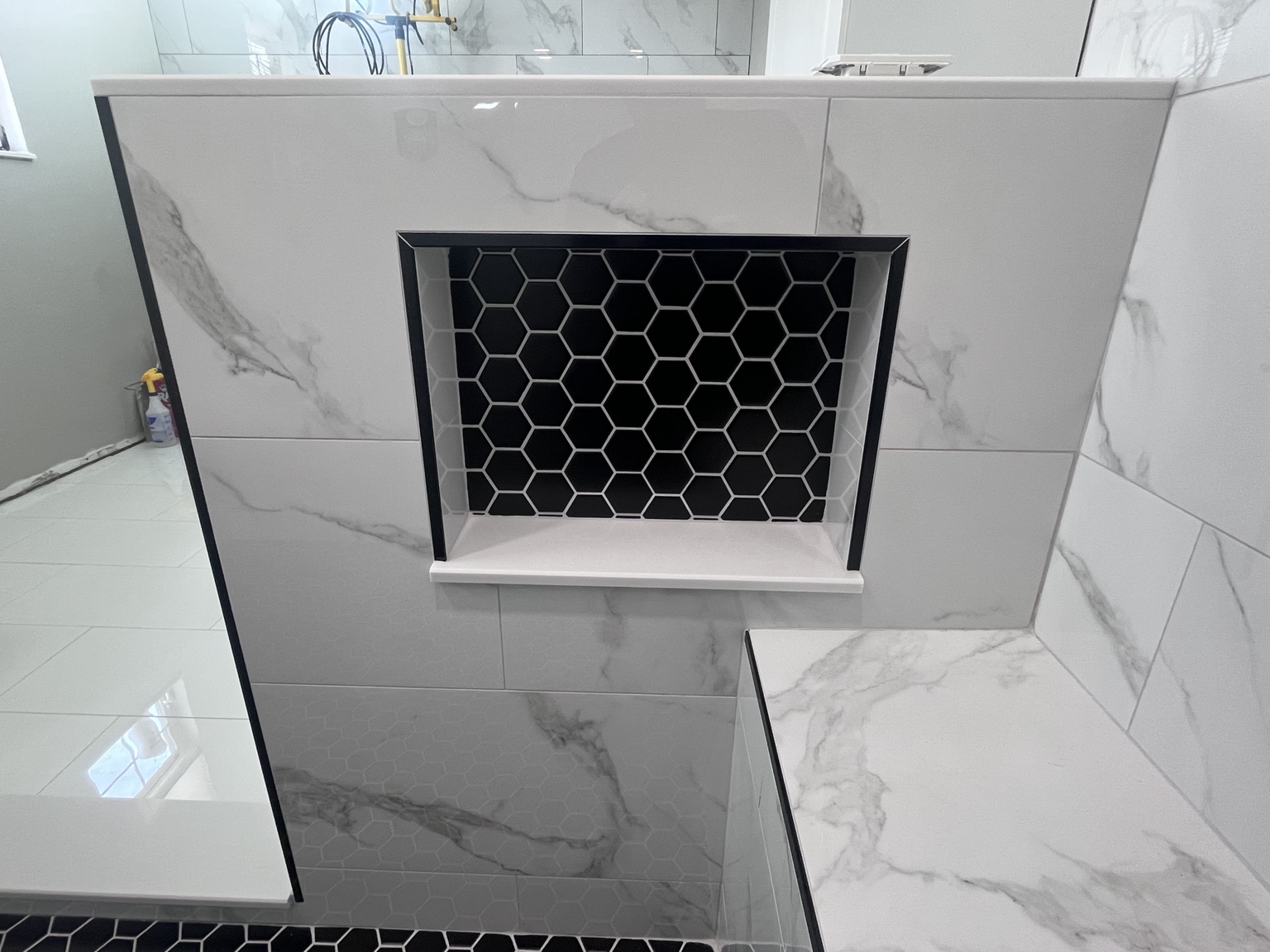 Black hexagon tile inside a shower niche