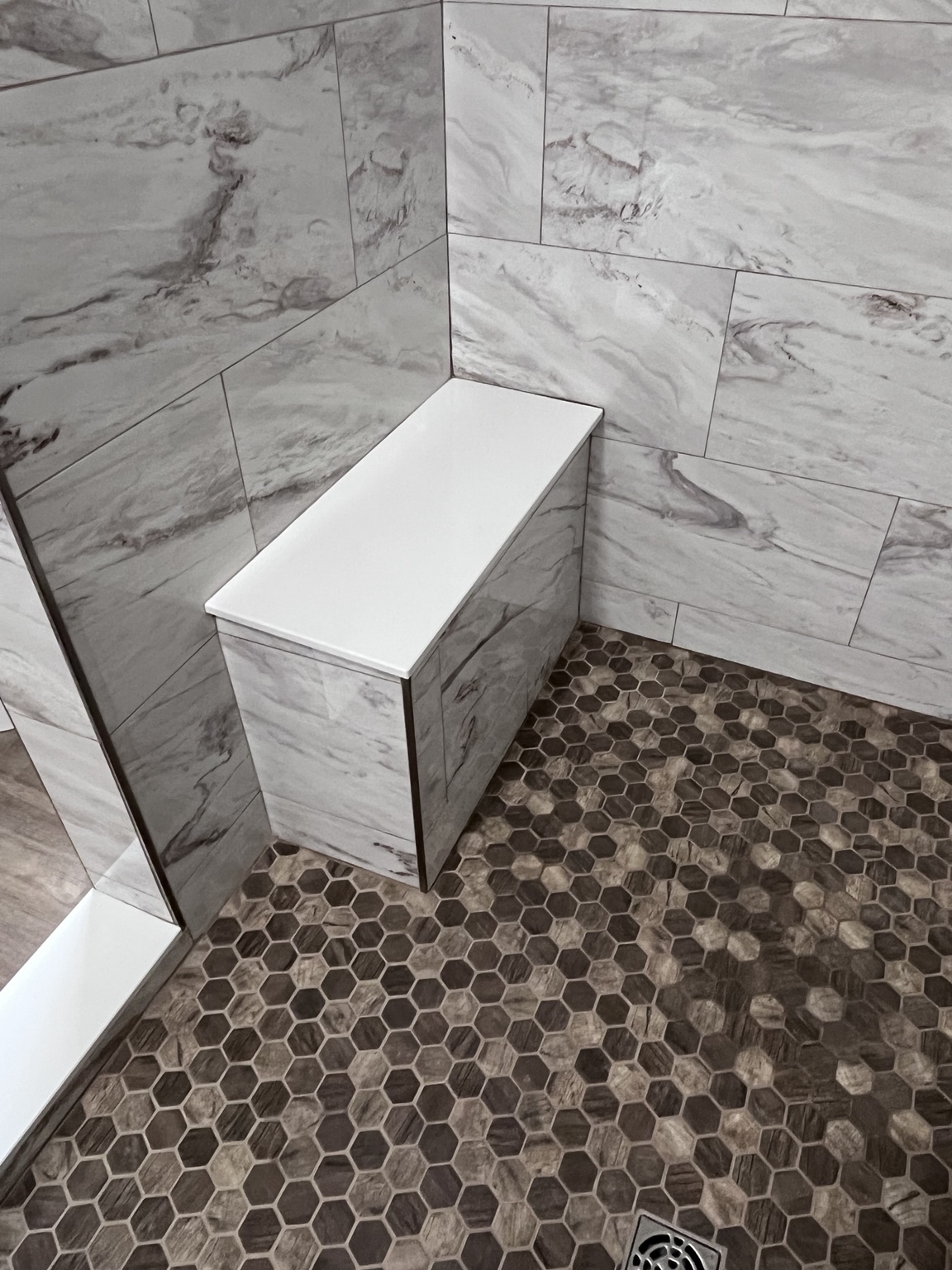 Tiled shower bench above a pebble floor
