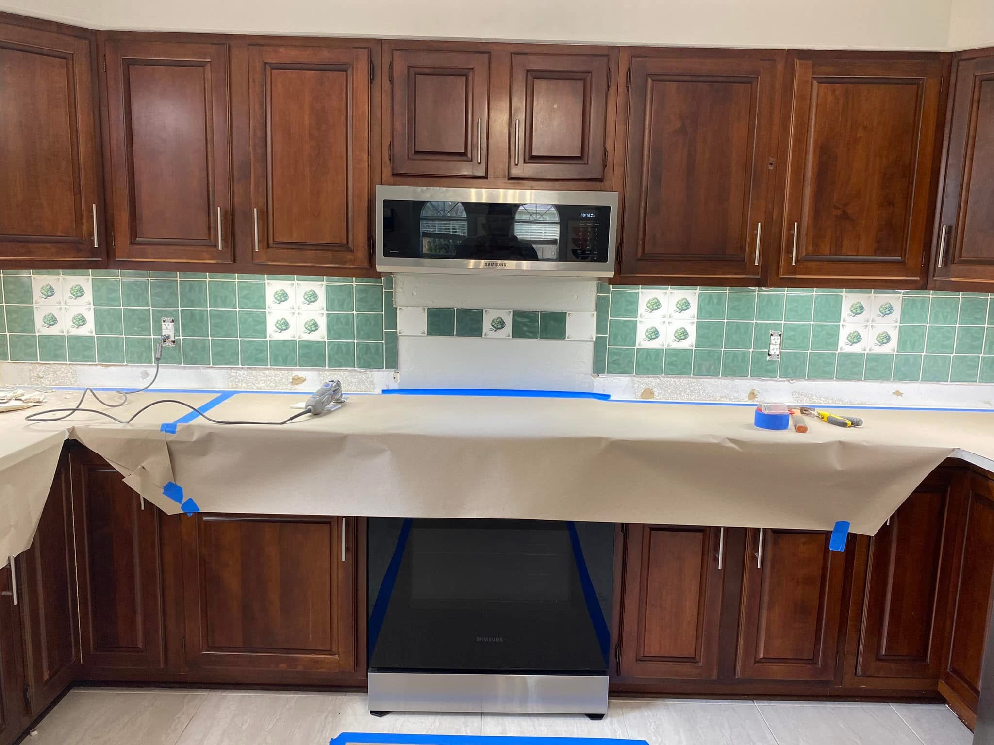 Dated green kitchen backsplash before removal